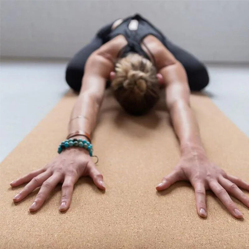 Person lying on a cork mat with hands and feet extended